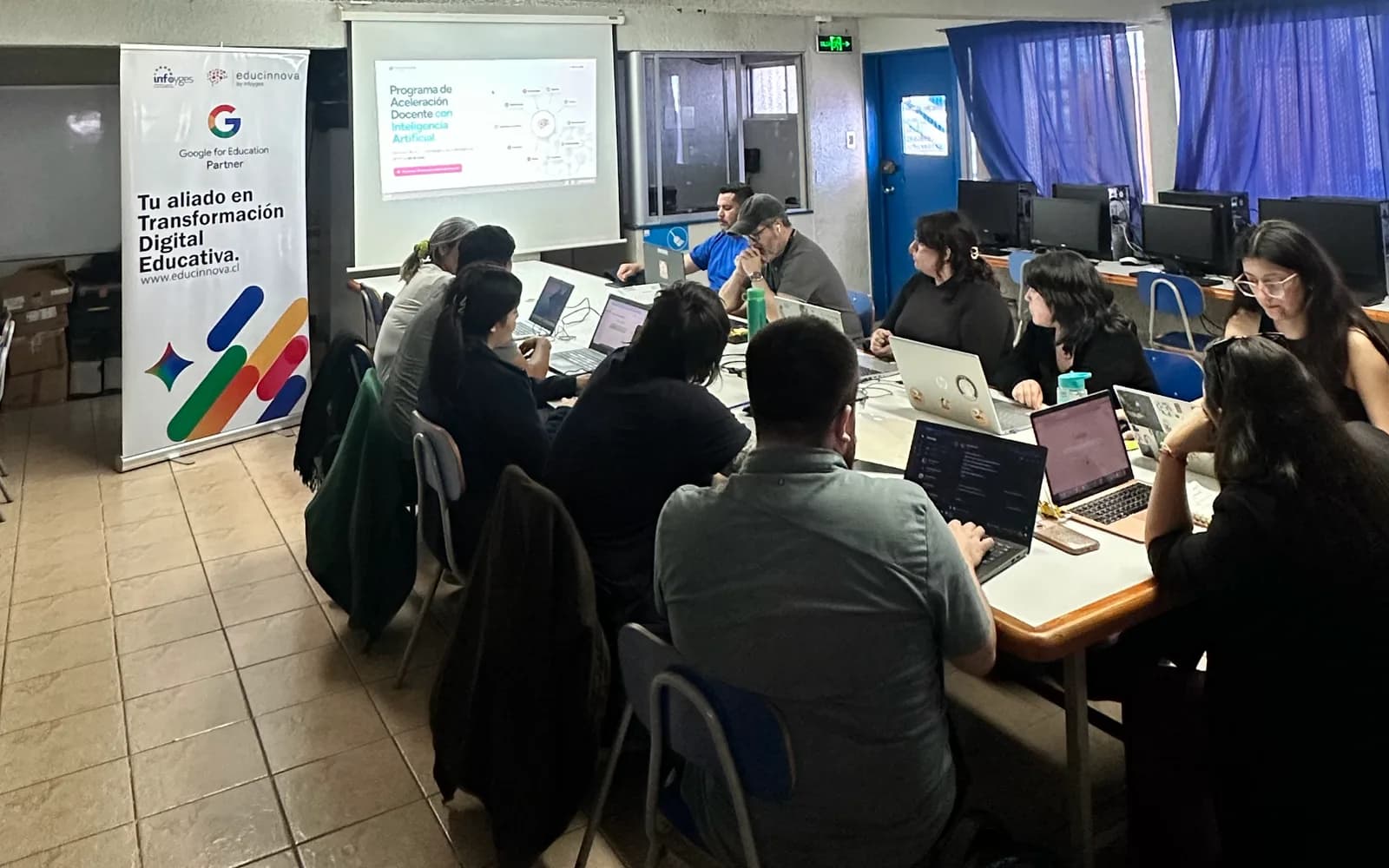 Docentes reunidos alrededor de una mesa durante un taller con portátiles y material de Educinnova.