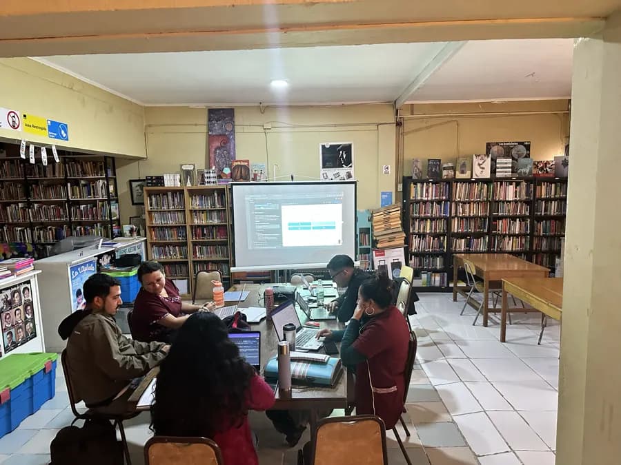 Equipo docente desarrollando actividades colaborativas en una biblioteca.