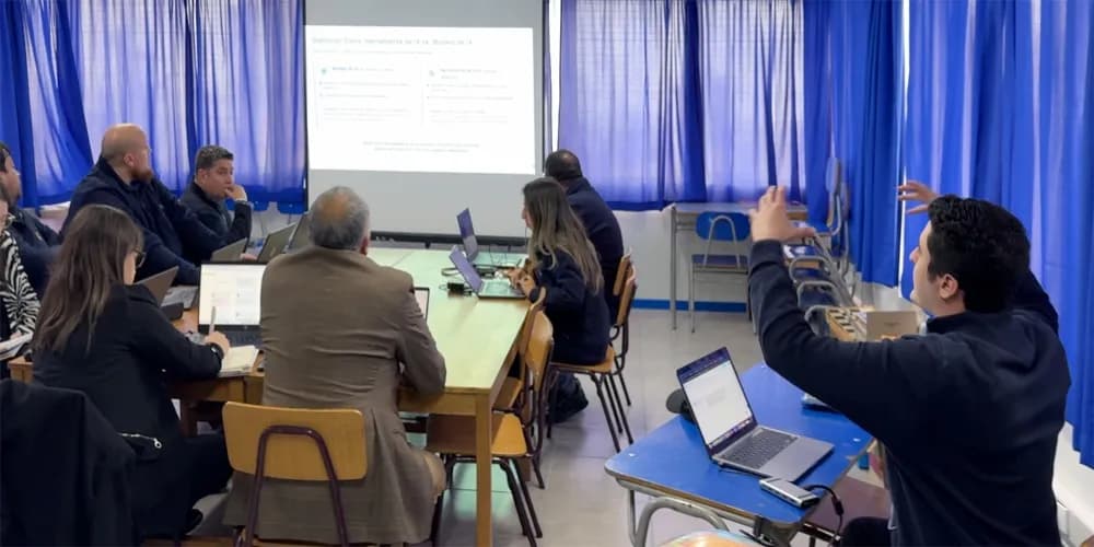 Docentes con laptops frente a una presentación en un taller de Educinnova.