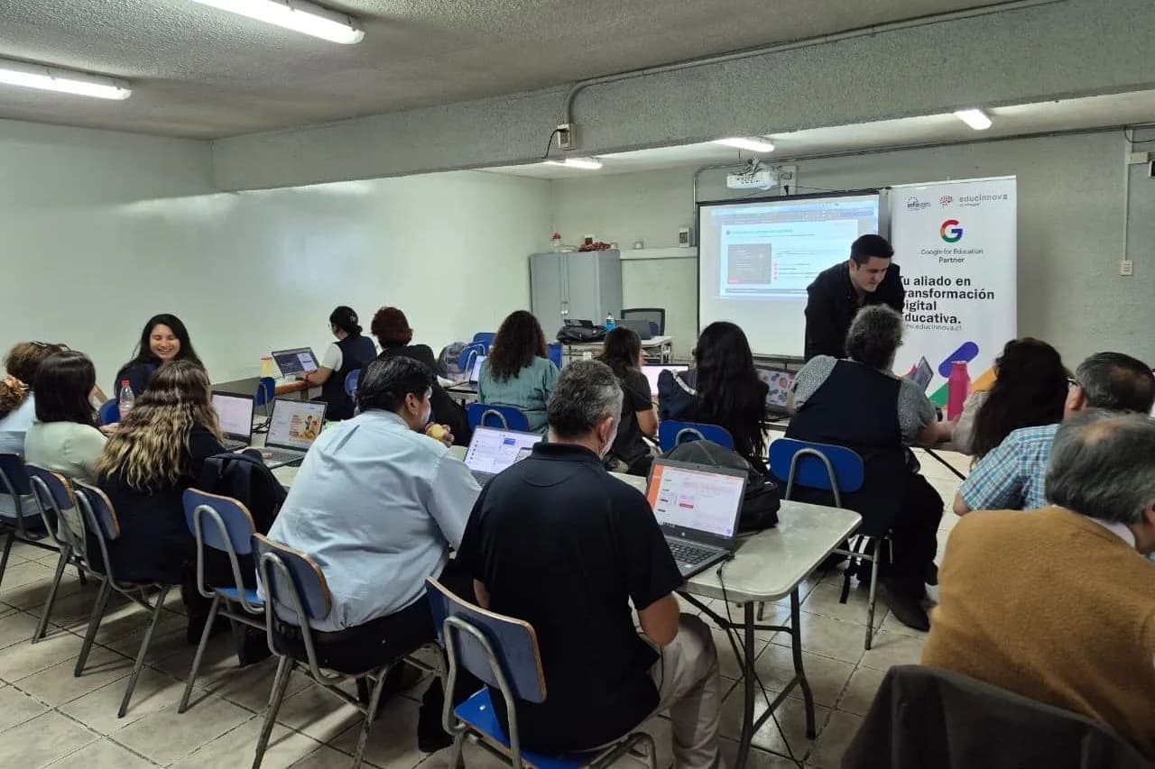 Docentes trabajando con portátiles mientras un formador de Educinnova los acompaña en el aula.